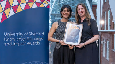 Lauren Rea holding a certificate with a colleage at an award ceremony