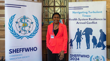 University of Sheffield Africa Scholarship winner Taofeekat Adigun stood between two stand-up banners at an academic conference.
