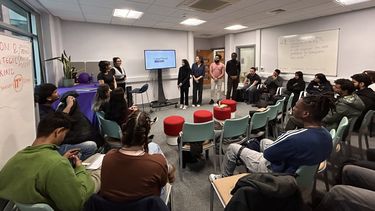Group presentation with students watching in medium sized room