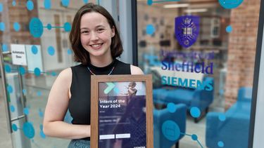 Flora Hippisley-Cox holding the Intern of the Year award