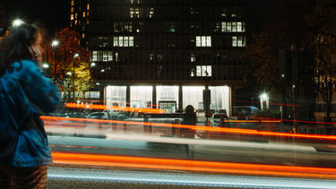 Someone on their phone outside the Arts Tower at night