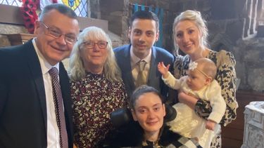 Gemma and family at the christening of her baby niece, Gemma is sat in a mobility aid