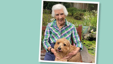 Marion Wiles smiling to the camera next to her dog.