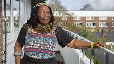 A woman standing outside her flat