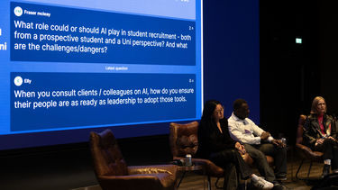 Serena Wong, Segun Osu and Martha Bennett answering questions from the board behind them discussing AI
