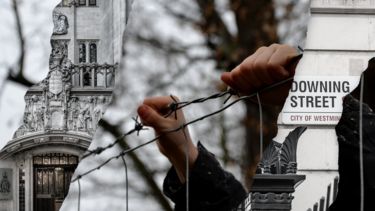 Collage style graphic depicting Downing street alongside a person holding onto barbed wire - a visual commentary of the Rwanda deal