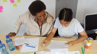 Two people looking at a selection of papers on a table