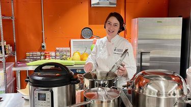 A person cooking in an industrial kitchen.