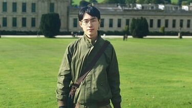 Student stood outside a country house