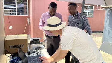 Dr Ning Ma preparing sound recording equipment at Kanyama Level One Hospital, Lusaka, with Dr David Singini and Mr Warren Lungu of CIDRZ.