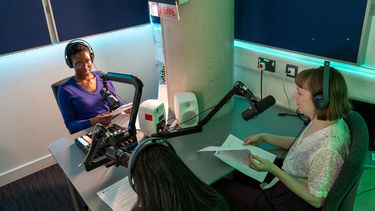 Two people conducting a podcast interview in a recording studio