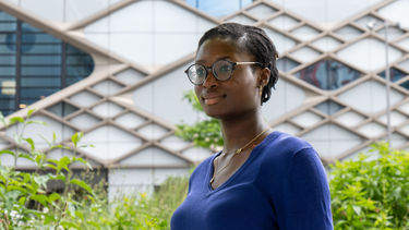 Person with glasses and blue jumper outside Diamond building