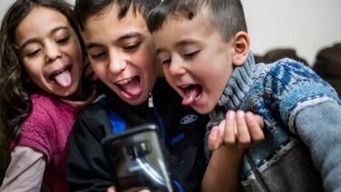 Three children playing on a videogame