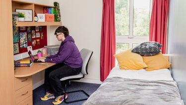 Student using laptop in en-suite at Endcliffe 