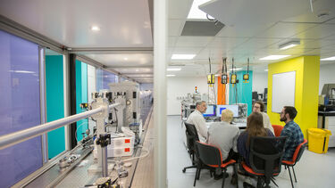 Researchers sit across from specialised laboratory equipment