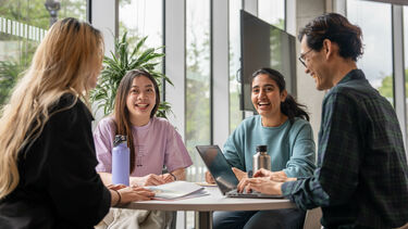Four young people sitting at a coffee table