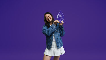 Student Joey holds the University of the Year trophy