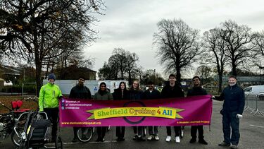 A group of students stood outside holding a Sheffield Cycling 4 All banner