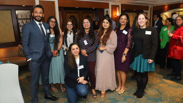 Several alumni gathered for a picture at a drinks reception