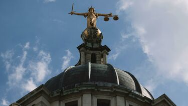 A golden statue on top of the Old Bailey courthouse