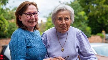 A smiling carer with an elderly woman