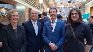 Four smiling people in formal dress.