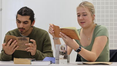 history students lookn at old books