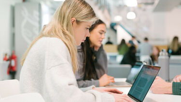Student using laptop in the Management School's cafe area