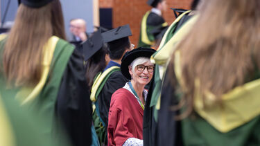 Staff volunteer at graduation  looking happy