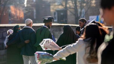 Sun shining outside with graduates on concourse