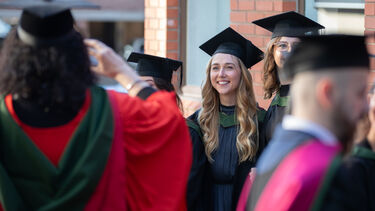 Graduates happy on concourse having photo taken