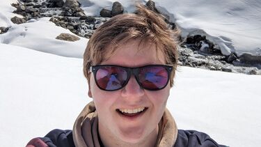 Person smiling at the camera, surrounded by snow.