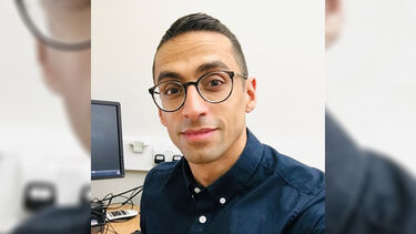 Dr Ali at a desk with a computer