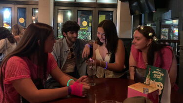 Students sat at a bar table chatting