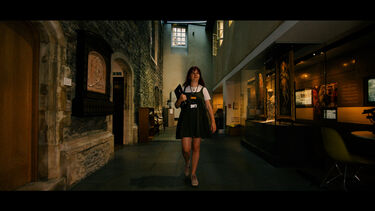 Rebecca Raven walking along a museum corridor