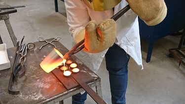 A person pouring molten glass