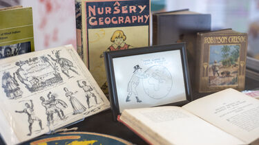 A display cabinet with a range of books and illustrations. 
