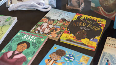 A display cabinet with a selection of children's books, including 'The story of Afro Hair' 