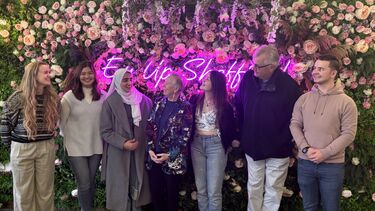 Ann and Jim Cairns posing for a photograph with a group of student scholars