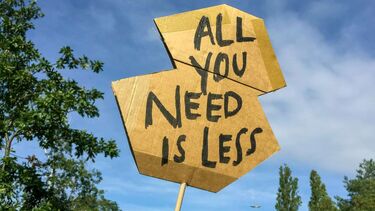 A homemade sign reading "All you need is less"