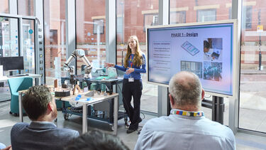 Student presenting in front of a screen in DIZ 