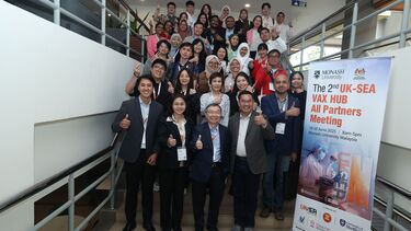 A group of conference delegates pose on a staircase 