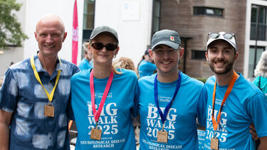 A group of smiling Big Walk 2025 participants at the finish line, displaying their medals