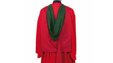 Back of a person wearing formal graduation robes for a Doctorate of Philosophy (PhD)