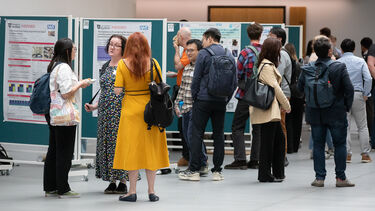 People gathered around a poster display talking