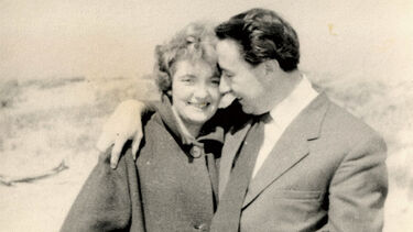 Black-and-white image of Arthur and Iris Higginbottom in their 40s, smiling with an arm around each other