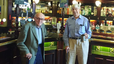 Bill Walsh and Bernard Tinker as older men, standing by the bar at the University Arms pub
