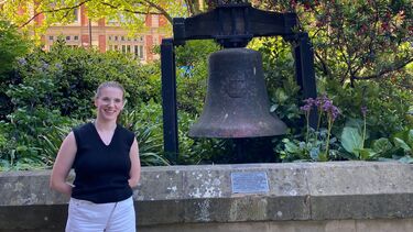 University of Sheffield student Holly Satterly stood next to the Bochum Bell in Sheffield's Peace Gardens