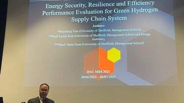 Huazhang presenting research at the conference. Screen is behind him. 