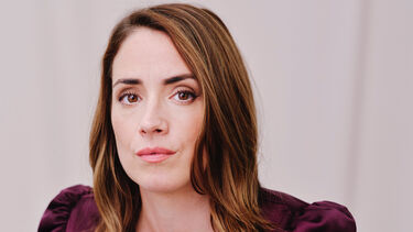 Headshot of a person with light brown eyes and medium length straight hair